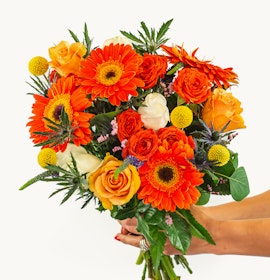 Bright floral bouquet featuring vibrant orange gerberas, roses, and playful yellow accents.