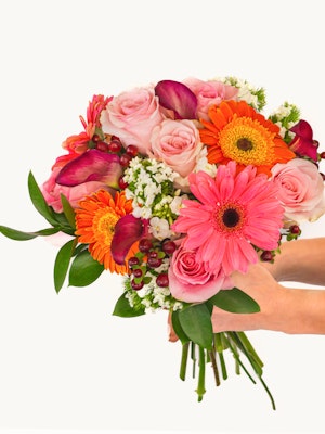 Vibrant floral bouquet featuring pink roses, orange gerberas, and greenery, ideal for celebrations.