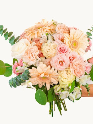 A lovely pastel bouquet featuring roses, gerbera daisies, and lush greenery.