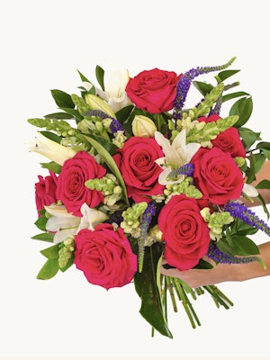 Vibrant bouquet of pink roses, white lilies, and green foliage, perfect for any celebration.