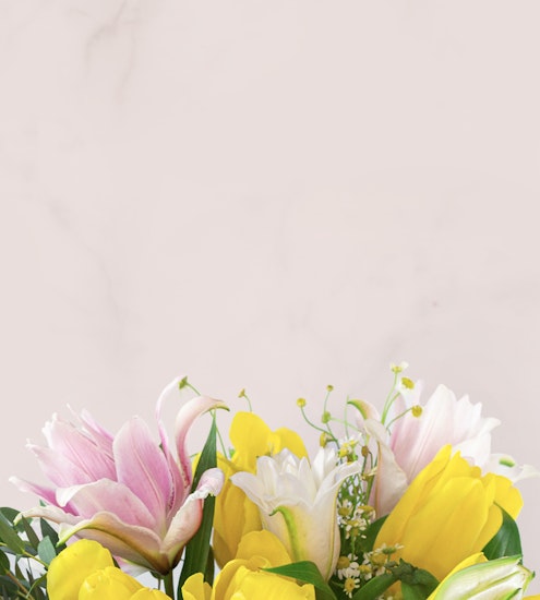 Vibrant floral arrangement featuring yellow tulips, pink lilies, and delicate greenery.