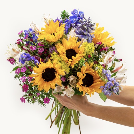 Bright sunflower bouquet featuring purple and pink blooms, perfect for cheerful occasions.