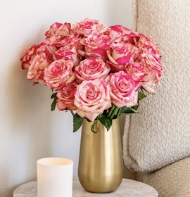 A stunning bouquet of pink and cream roses in a gold vase, perfect for any occasion.
