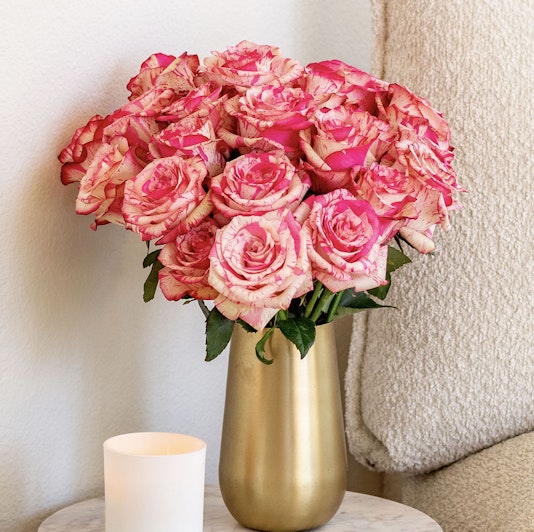 A stunning bouquet of pink and cream roses in a gold vase, perfect for any occasion.