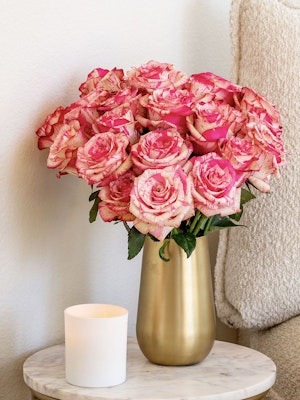 A stunning bouquet of pink and cream roses in a gold vase, perfect for any occasion.